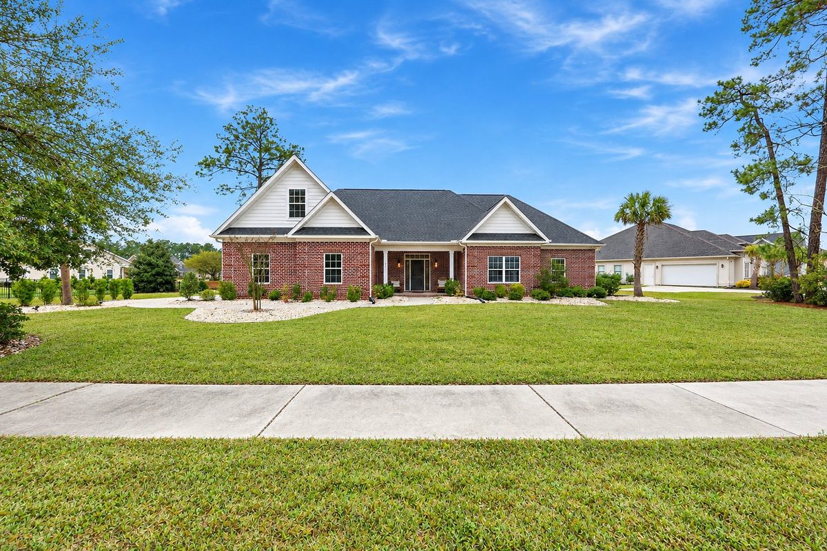 A brick ranch home with a wide front lawn in Wild Wing Plantation
